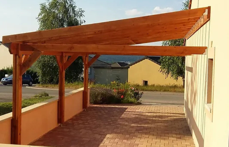 charpente bois pour un carport positionné sur un côté de la maison